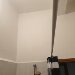 קיר צבוע בלבן עם וילון מקלחת