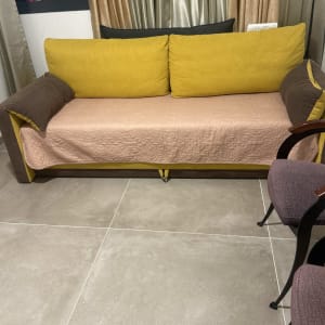 ספה עם כריות צהובות וכיסוי ורוד