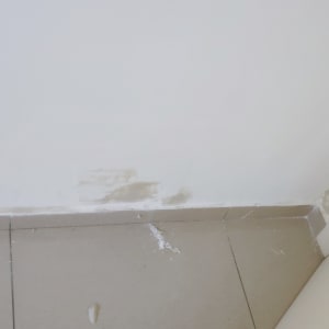 קיר עם תיקוני טיח ליד רצפה ודלת