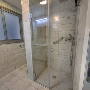 מקלחון זכוכית עם ראש מקלחת ומוט אחיזה