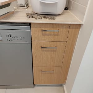 מכונת קפה על משטח עץ ליד מדיח כלים