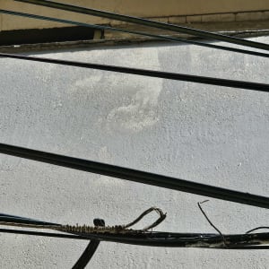 כבלים חשמליים קשורים על קיר בטון