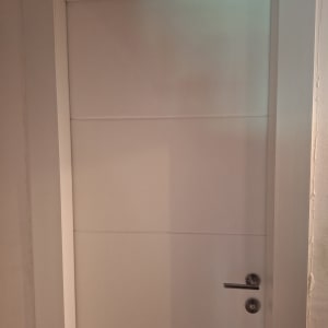 דלת פנים לבנה עם ידית מתכת