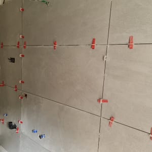 קיר עם אריחים אפורים ומחברים אדומים