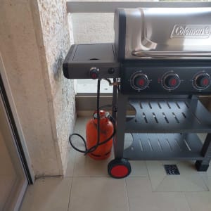 גריל גז עם בלון גז כתום במרפסת