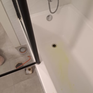 אמבטיה עם סימני נזילה וכלי עבודה על הרצפה