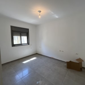 חדר ריק עם קירות צבועים בלבן ונורה בתקרה