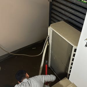 אדם עובד ליד דוד שמש עם צינורות מחוברים