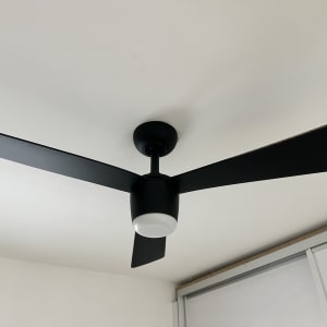 מאוורר תקרה שחור מותקן על תקרה לבנה