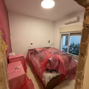 חדר עם רהיטים מכוסים בניילון לקראת צביעה
