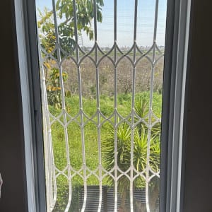 חלון אלומיניום עם סורגי מתכת לבנים