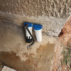 מסנני מים עם צנרת על רצפה רטובה