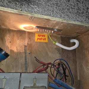 חוטי חשמל ותיבת חיבורים עם שלט אזהרה