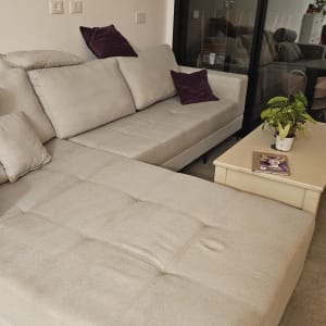 ספה בהירה עם כריות על רצפת אריחים