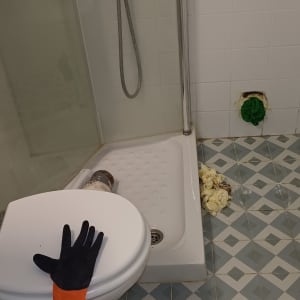 תיקון אינסטלציה בחדר אמבטיה עם כפפות וכלים