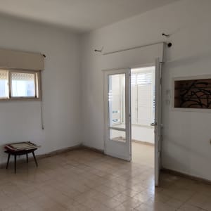 חדר ריק עם שולחן קטן וציור על הקיר