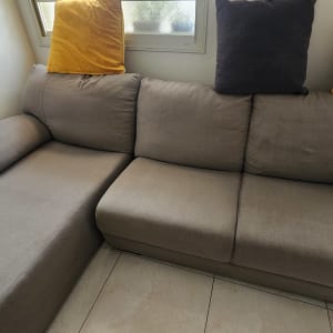 ספה אפורה עם כריות צבעוניות ליד חלון