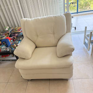 כורסה לבנה בחדר עם צעצועים על שולחן