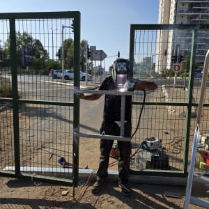 עובד מרתך שער מתכת ברחוב