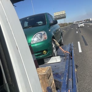 רכב ירוק על גרר בכביש מהיר