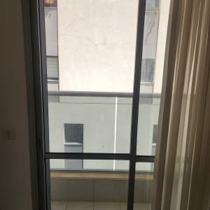 חלון זכוכית עם וילון ומרפסת חיצונית