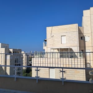 מעקה מתכת לבן על מרפסת גג