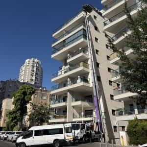 מנוף הרמה סולם מופעל לצד בניין מגורים רב קומות