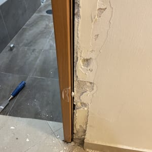 משקוף דלת עץ עם קיר מתקלף ותיקונים