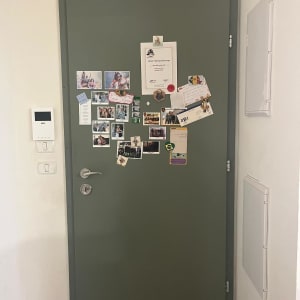 דלת ירוקה עם ידית כסופה ותמונות מודבקות