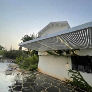 פרגולה מאלומיניום ליד בית עם גינה