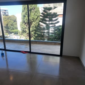 בקבוק תרסיס ומגב אדום על רצפה נקייה