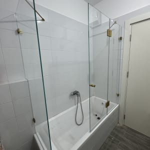 אמבטיה עם דלתות זכוכית וברז מקלחת