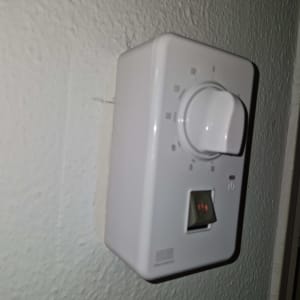 תרמוסטט מותקן על קיר עם כפתור ויסות