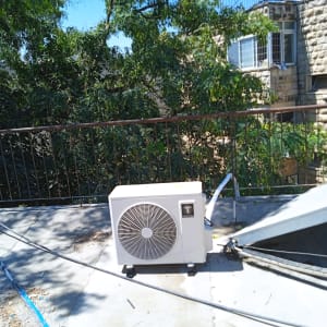 יחידת מיזוג אוויר על גג עם עצים ברקע