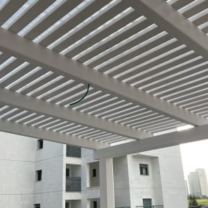 פרגולה מעץ לבן עם צינור ירוק תלוי