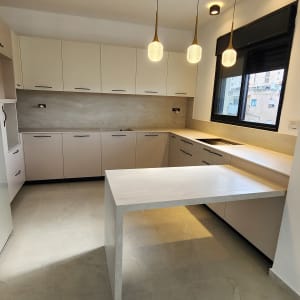 מטבח מודרני עם תאורה תלויה ושיש לבן