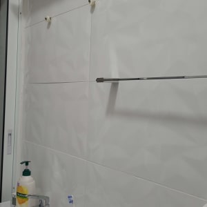 מדף מתכת מותקן על קיר אריחים לבנים