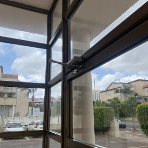 חלון זכוכית עם מחזיר דלת במבנה ציבורי