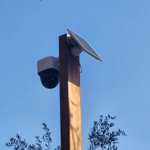 מצלמת אבטחה מותקנת על עמוד עץ עם פאנל סולארי