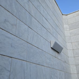 קיר עם תאורה חיצונית על רקע שמיים כחולים