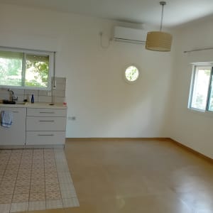 חדר ריק עם מטבח קטן ומזגן על הקיר
