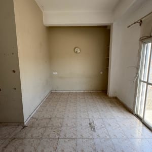 חדר ריק עם קירות בהירים ורצפת אריחים