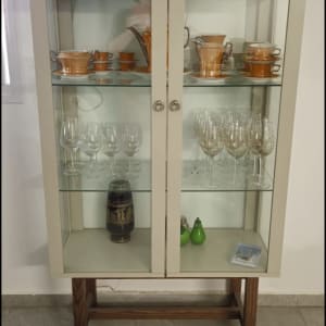 ארון זכוכית עם כלי חרסינה וכוסות יין