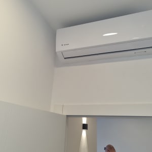 מזגן מותקן על קיר לבן עם תאורה