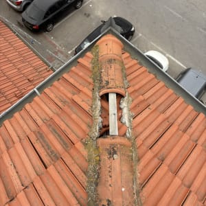 רעפים כתומים עם צינור מתכת על הגג