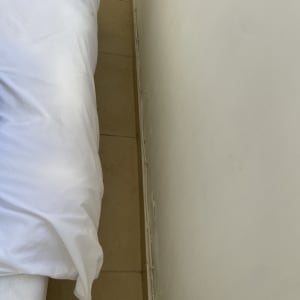 קיר לבן עם כרית לבנה על מיטה