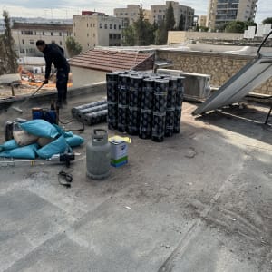 אדם עובד על איטום גג עם יריעות ביטומניות