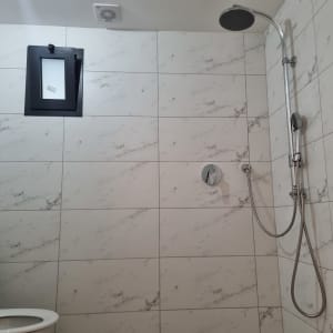 חדר אמבטיה עם אריחים חדשים ומקלחת מותקנת