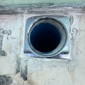 צינור מתכת בקיר עם טיח סביבו