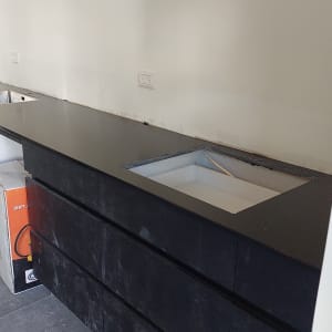 משטח שיש שחור עם כיור מובנה במטבח